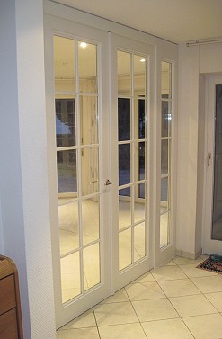 Blick aus dem Flur auf die zweiflgelige Zimmertr die als thermische und akustische Abtrennung zwischen Wohnzimmer und Flur dient.